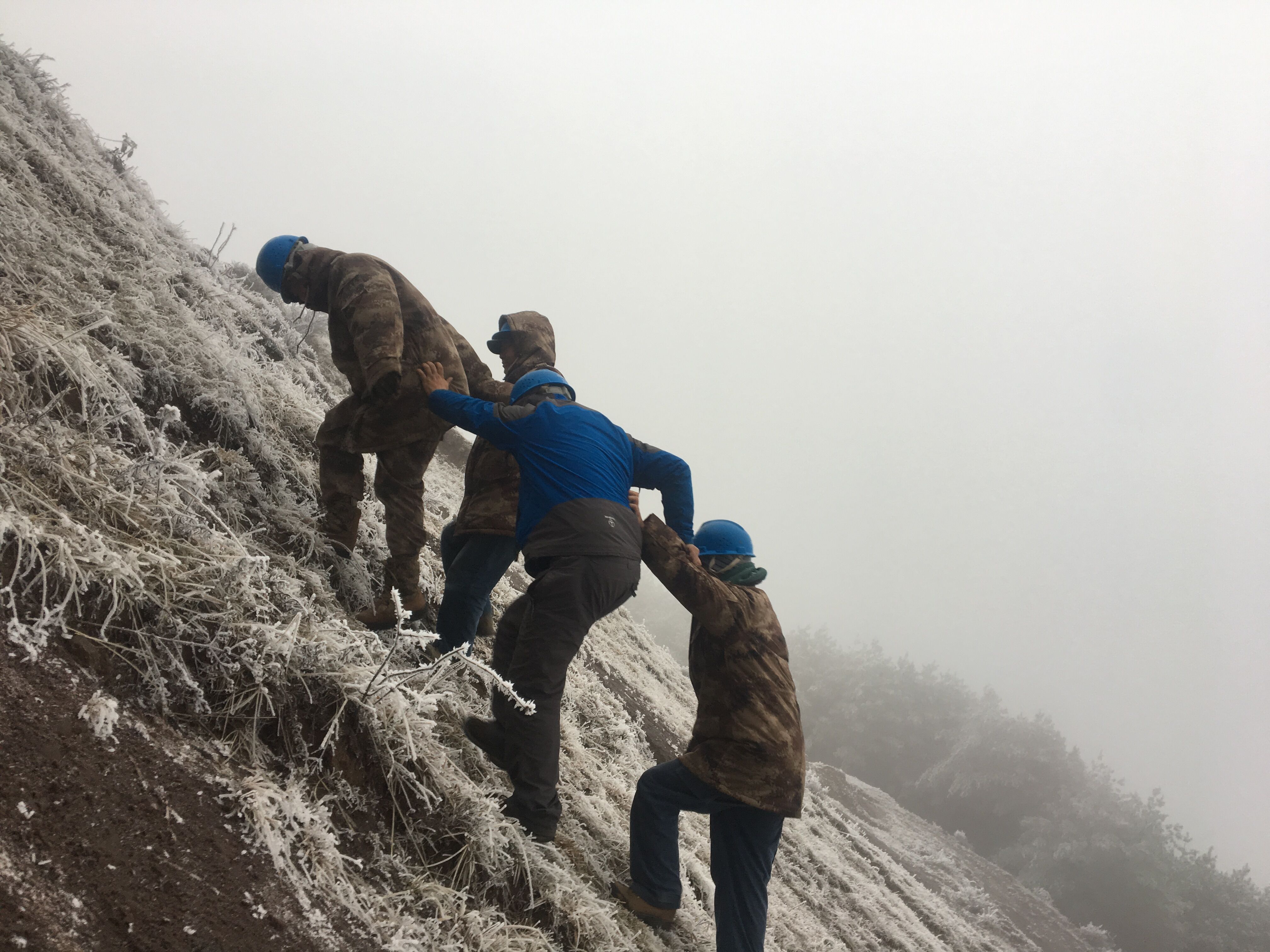 互相攙扶，勇登高峰。（李健攝）